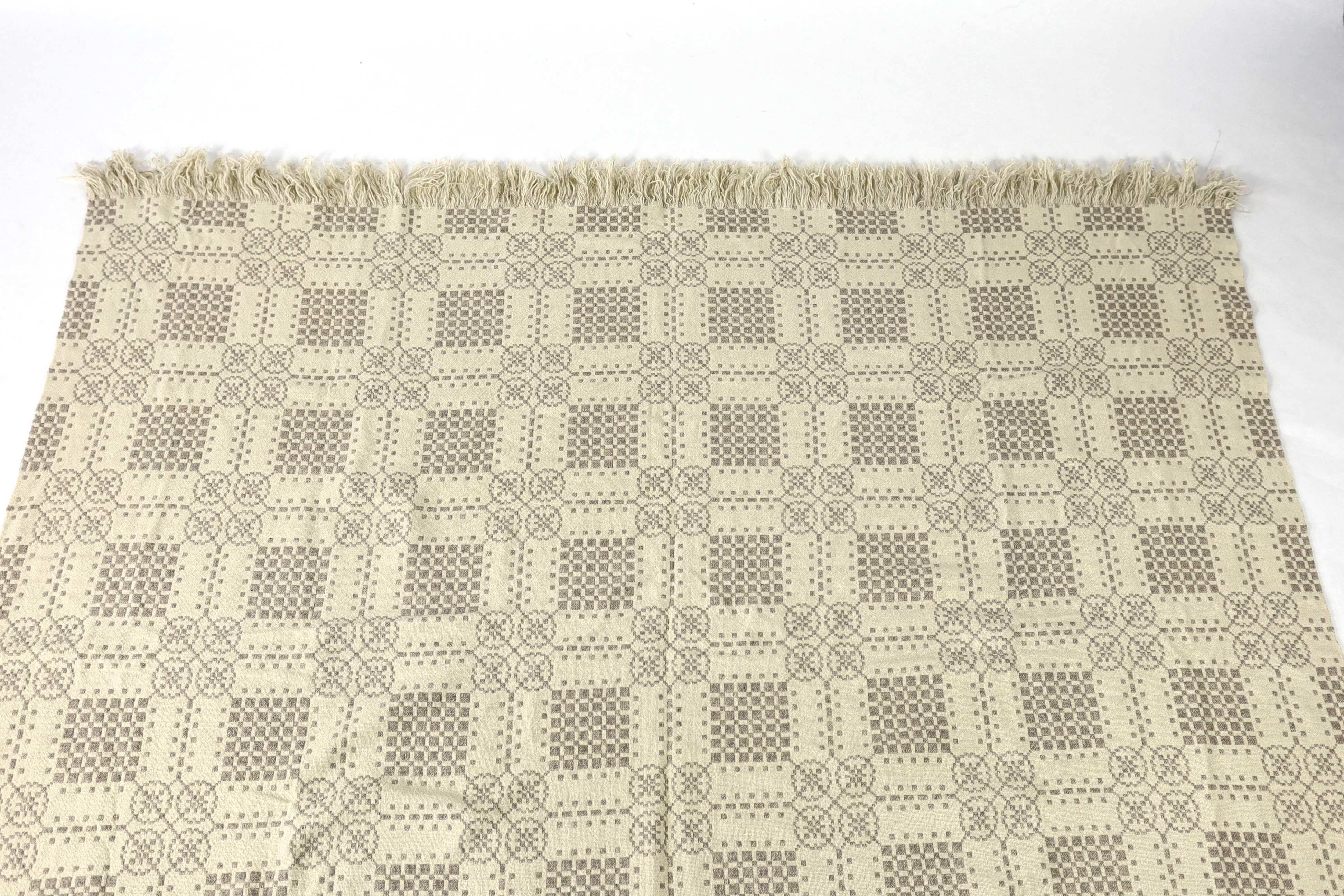 A Welsh wool woven blanket, using mushroom and cream wool in a reversible geometric design, 192cm wide x 212cm long